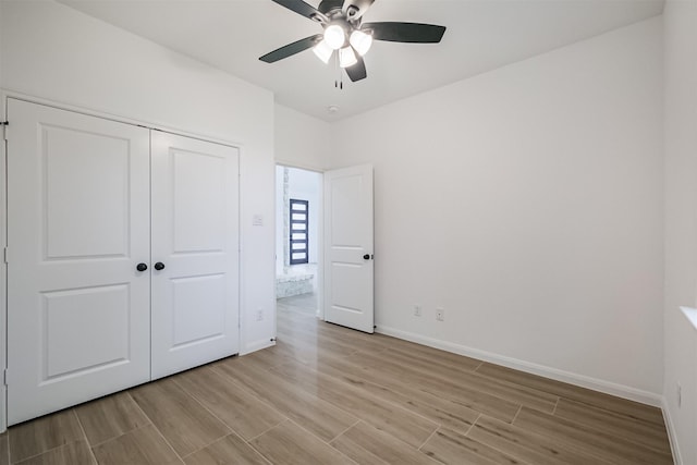 unfurnished bedroom featuring ceiling fan and a closet