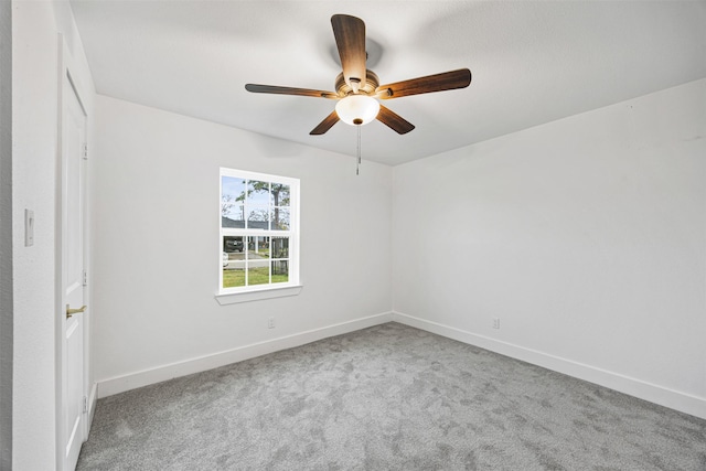 empty room featuring ceiling fan and carpet