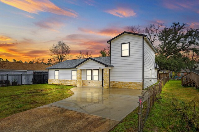 view of front of property with a patio area and a yard