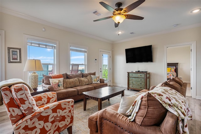 living room with ceiling fan, ornamental molding, and light hardwood / wood-style flooring