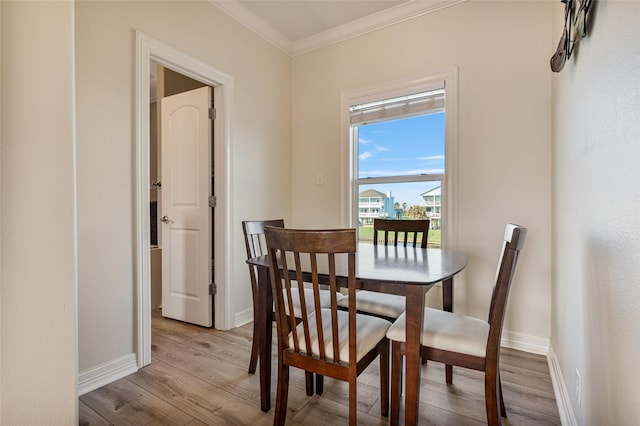 dining area with crown molding and light hardwood / wood-style flooring