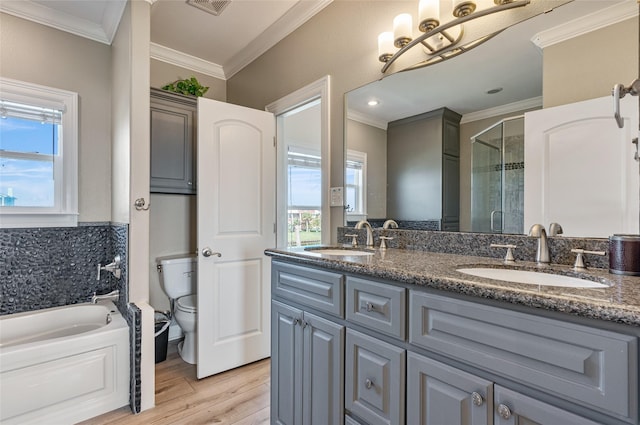 full bathroom featuring ornamental molding, separate shower and tub, toilet, vanity, and hardwood / wood-style flooring