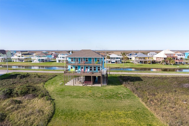 rear view of house with a lawn and a water view