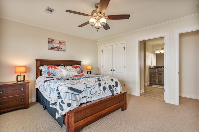 carpeted bedroom with connected bathroom, a closet, ceiling fan, and ornamental molding