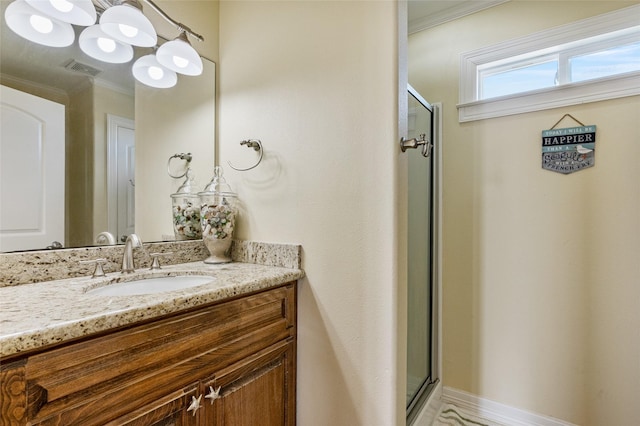 bathroom featuring vanity, a shower with door, and ornamental molding