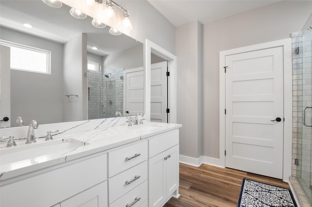 bathroom featuring hardwood / wood-style flooring, vanity, and a shower with shower door