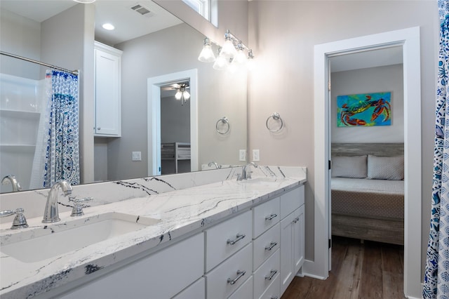 bathroom with hardwood / wood-style flooring, ceiling fan, and vanity