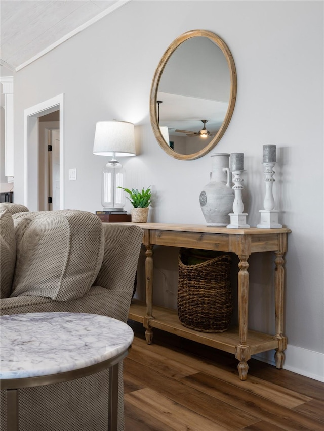 sitting room featuring ceiling fan, crown molding, and dark wood-type flooring