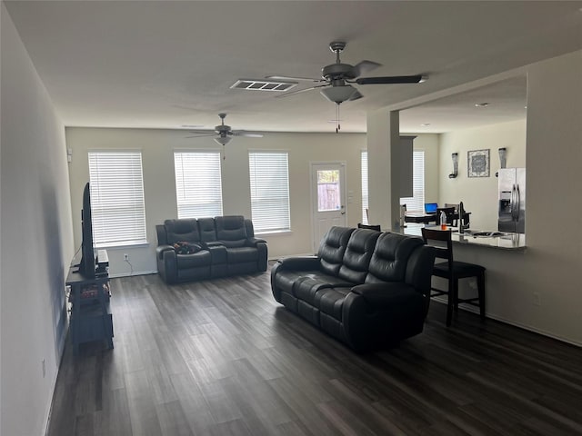 living room featuring ceiling fan and dark hardwood / wood-style floors