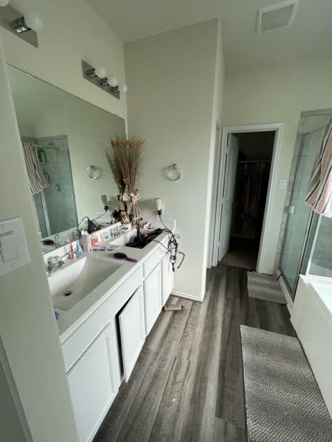 bathroom featuring independent shower and bath, vanity, and hardwood / wood-style flooring