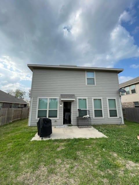 rear view of property featuring a patio and a yard