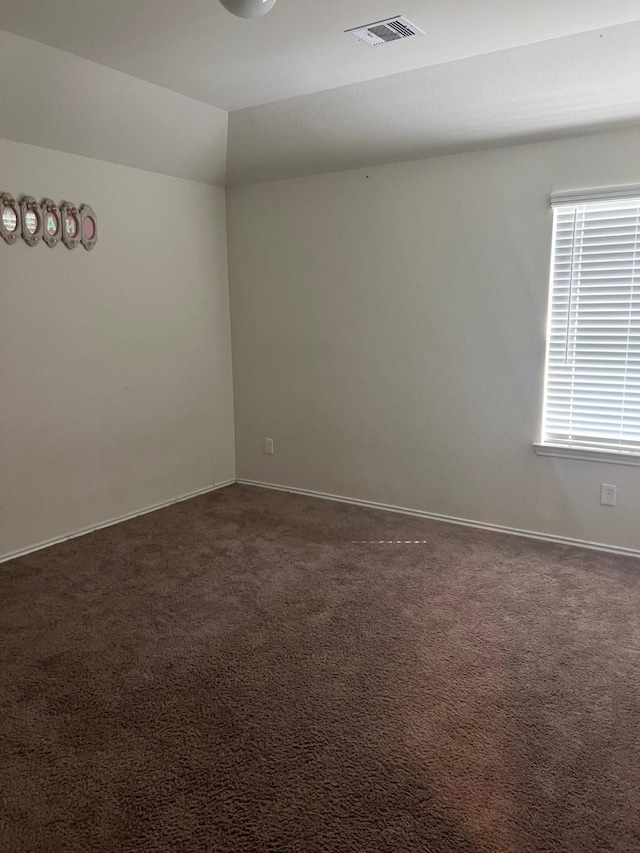 carpeted spare room with lofted ceiling