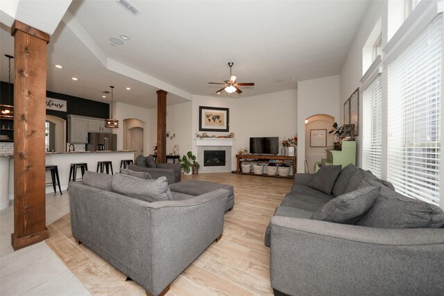 living room featuring decorative columns and ceiling fan