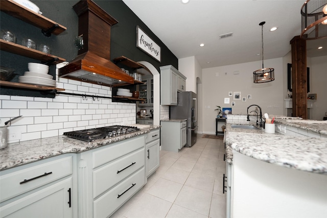 kitchen featuring light stone countertops, appliances with stainless steel finishes, tasteful backsplash, sink, and light tile patterned floors