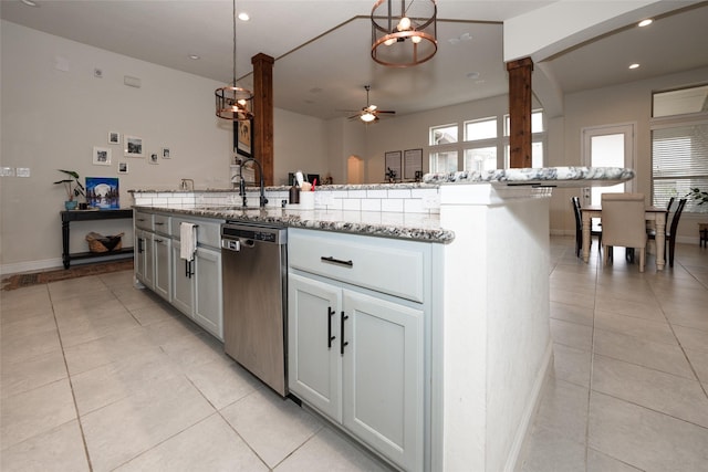 kitchen with ceiling fan, dishwasher, sink, hanging light fixtures, and a center island with sink