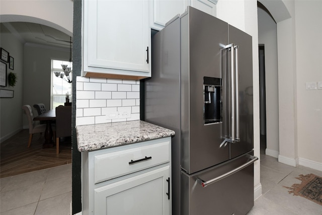 kitchen featuring light tile patterned floors, white cabinetry, light stone counters, and high quality fridge