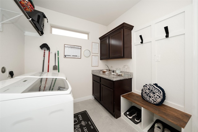 washroom with light tile patterned flooring, cabinets, sink, and washing machine and clothes dryer