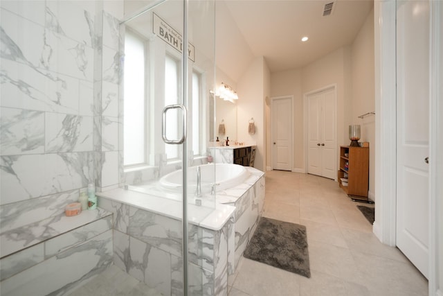 bathroom featuring tile patterned floors, tiled bath, and vanity