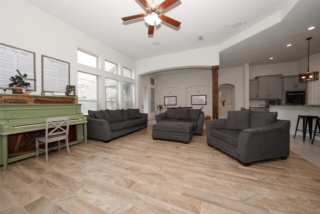 living room with light hardwood / wood-style flooring and ceiling fan