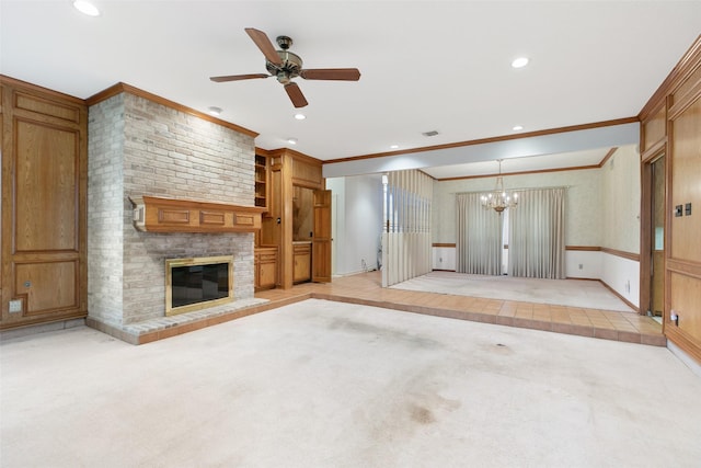 unfurnished living room with ceiling fan with notable chandelier, a fireplace, ornamental molding, and light carpet