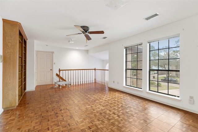 empty room with ceiling fan and parquet floors