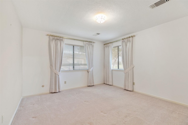 carpeted spare room with a textured ceiling