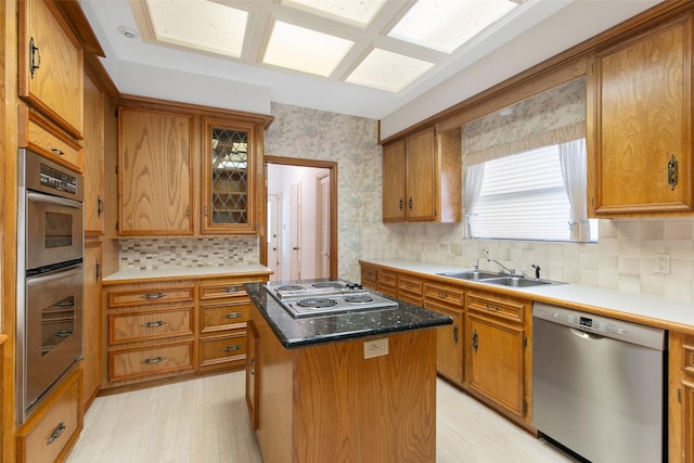 kitchen featuring stainless steel appliances, a kitchen island, sink, and tasteful backsplash