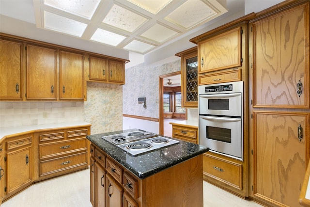 kitchen with electric cooktop, a center island, backsplash, dark stone counters, and double oven