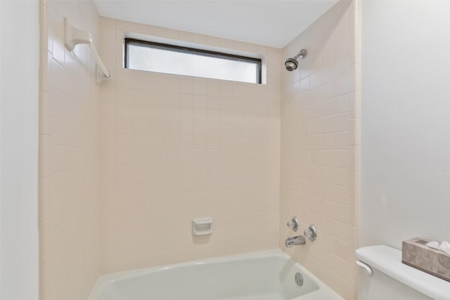 bathroom with toilet and tiled shower / bath