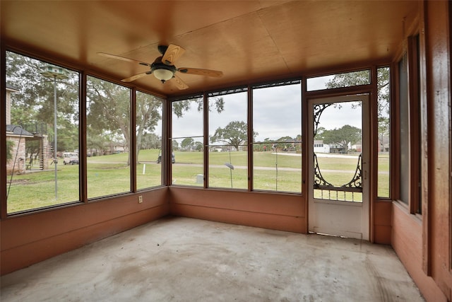 unfurnished sunroom with ceiling fan