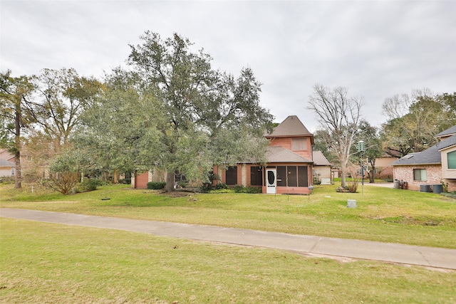 view of front of property featuring a front yard and a sunroom