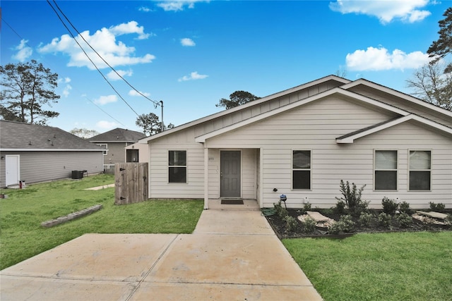 view of front of property with central AC unit, a patio area, and a front lawn