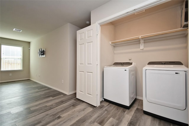 laundry room with washer and clothes dryer and wood-type flooring