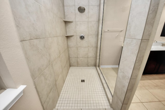 bathroom with vanity, a tile shower, and tile patterned floors