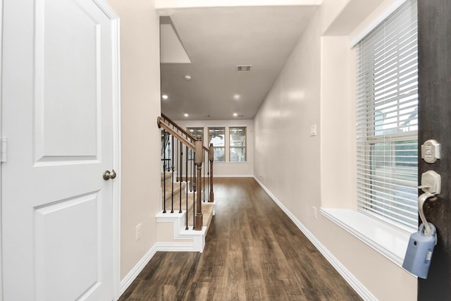 entrance foyer with dark wood-type flooring and a healthy amount of sunlight