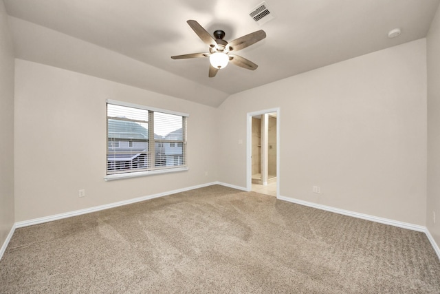 carpeted spare room with ceiling fan and vaulted ceiling