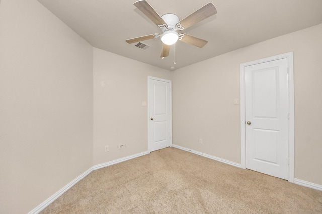 carpeted spare room with ceiling fan