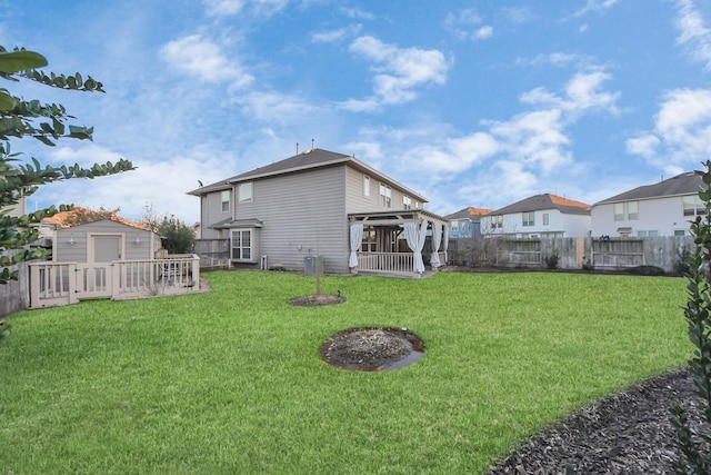 rear view of property featuring a yard, central AC, and a storage shed