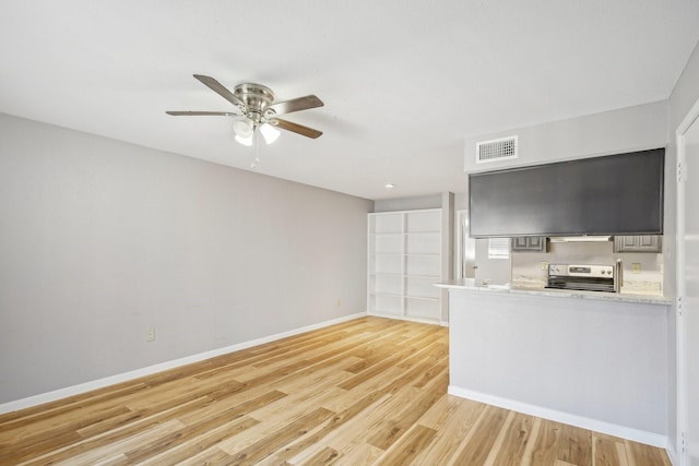 kitchen featuring light wood finished floors, electric range, baseboards, a ceiling fan, and light countertops