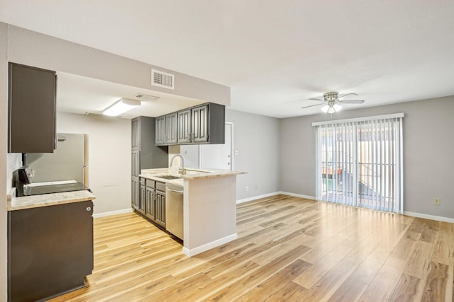 kitchen with light wood-style flooring, stainless steel appliances, visible vents, baseboards, and light countertops