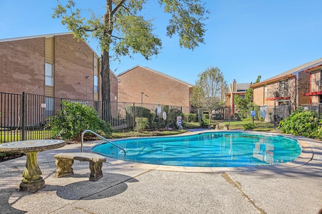 pool with a patio area and fence