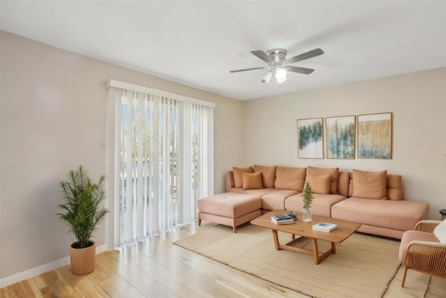 living room featuring a ceiling fan, light wood-style flooring, and baseboards