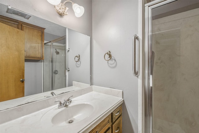 bathroom featuring a shower with door and vanity