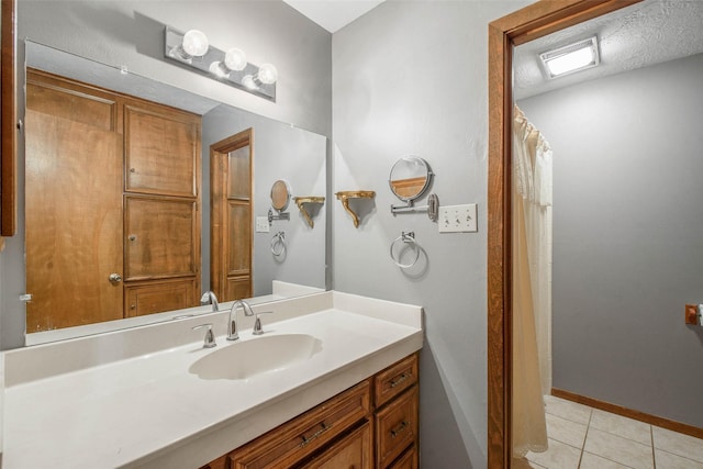 bathroom featuring vanity, a textured ceiling, tile patterned floors, and walk in shower