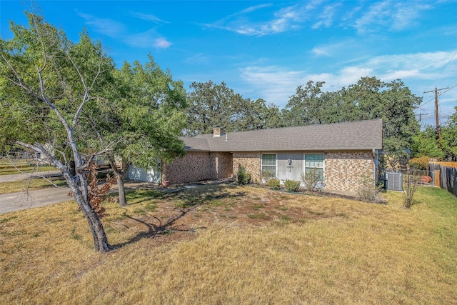 ranch-style home featuring central AC unit and a front lawn