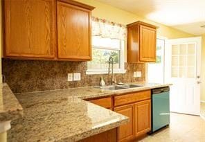 kitchen with dishwasher, backsplash, light stone countertops, and sink