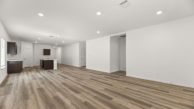 unfurnished living room featuring wood finished floors, visible vents, and recessed lighting
