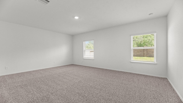 unfurnished room with visible vents, baseboards, recessed lighting, and carpet