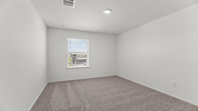 carpeted empty room with visible vents and baseboards