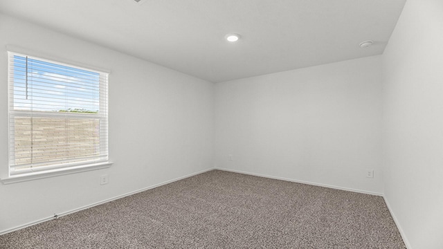 carpeted empty room with baseboards and recessed lighting